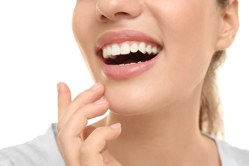 white woman smiling with hand on her chin